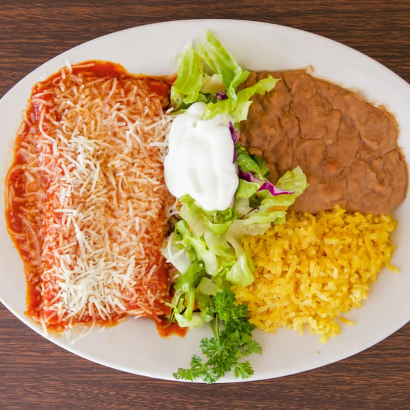 Taqueria Morena's enchilada plate with rice, refried beans, and a side salad with sour cream.