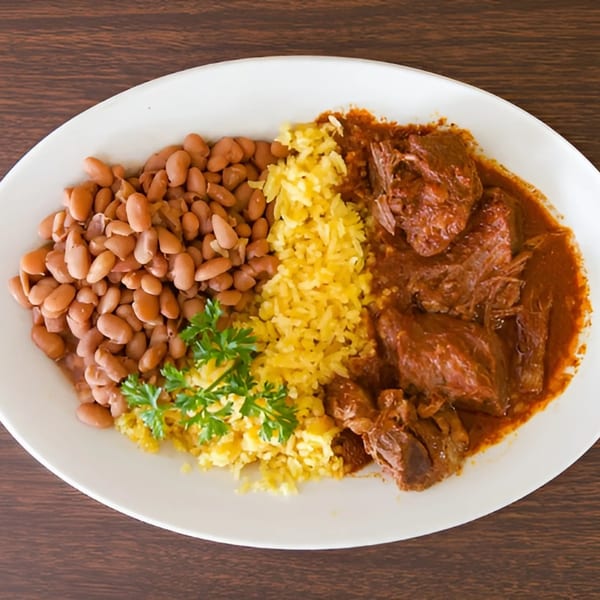 Taqueria Morena's Mexican dish with pinto beans, yellow rice, and stewed meat in red sauce.